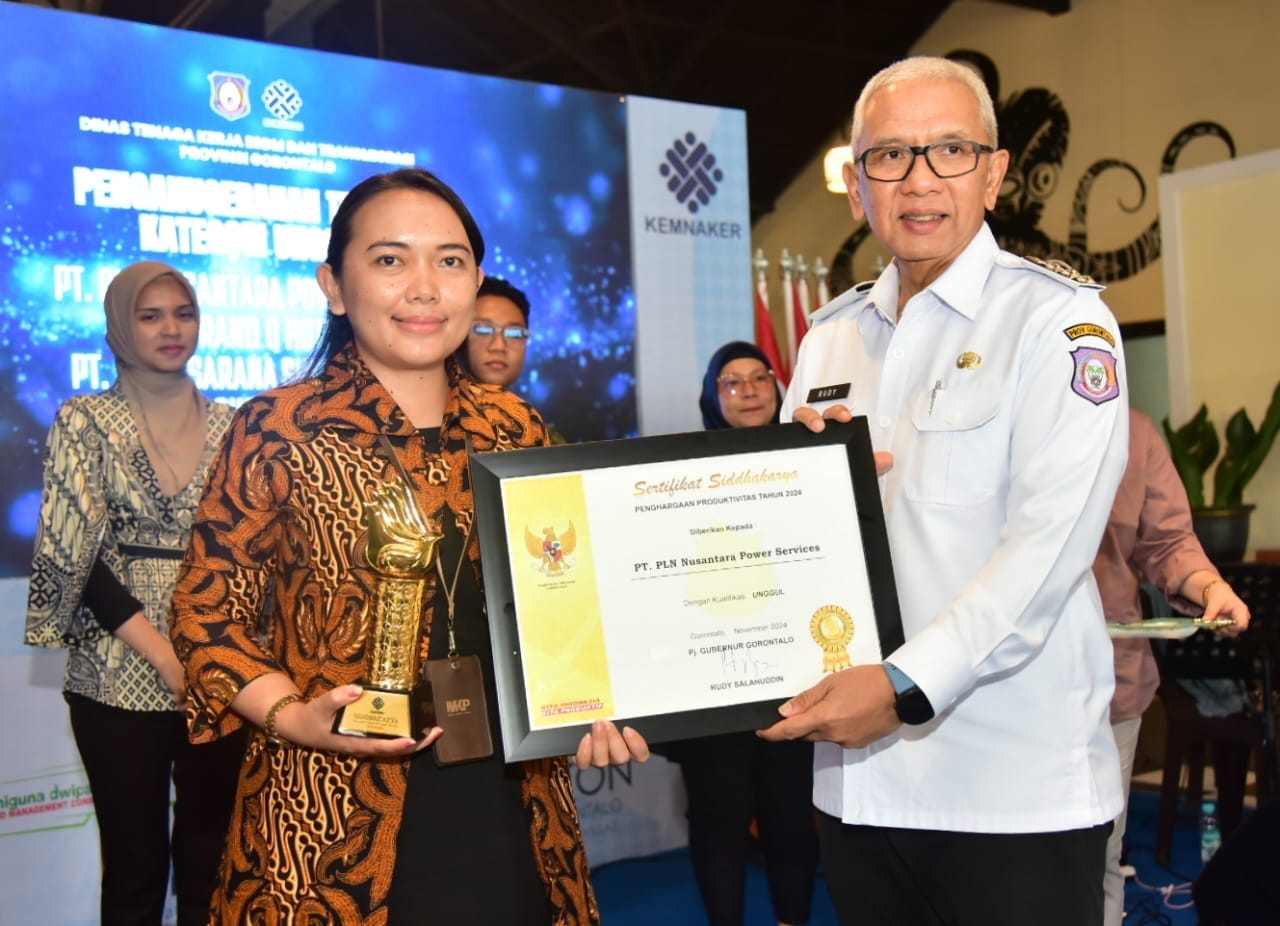 Pj Gubernur Gorontalo Rudy Salahuddin saat memberikan piagam penghargaan Siddhakarya kepada salah satu perusahaan yang dinilai berhasil menciptakan karya unggul dan berkualitas tinggi di Provinsi Gorontalo, di Oceana Resto and Resort, Rabu (13/11/2024). (Foto – Nova Diskominfotik)