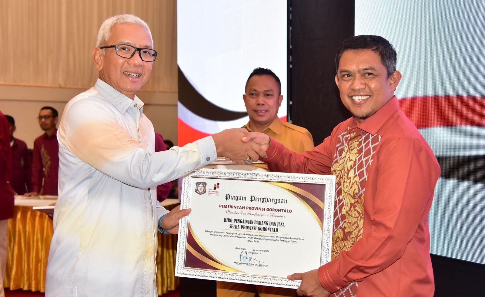 Gubernur Gorontalo Rudy Salahuddin saat menyerahkan piagam penghargaan kepada OPD di lingkup Pemerintah Provinsi pada pelaksanaan peringatan Hakordia 2024, di Grand Palace Convention Center (GPCC), Kota Gorontalo, Selasa (3/12/2024). Foto – Fadil Diskominfotik