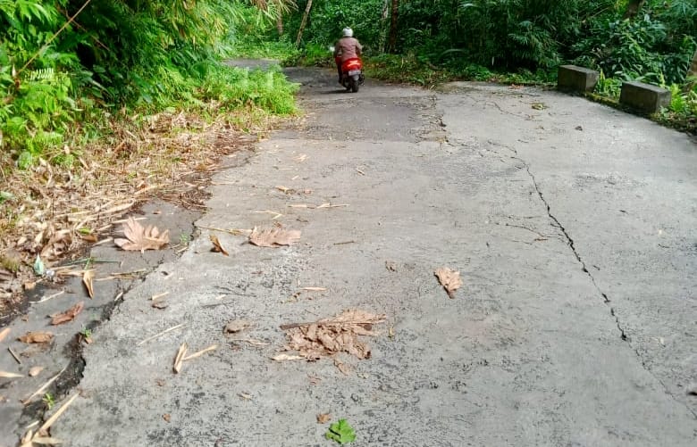 Kondisi jalan masuk Kampung Talawid Kecamatan Kendahe, turunan curam, aspal terkelupas, licin karena lumut. (Foto: AM. Budiman)